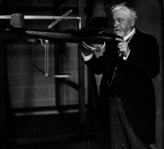 Gustave Eiffel dans son laboratoire tient 1 maquette de l'avion conçu par Victor Tatin